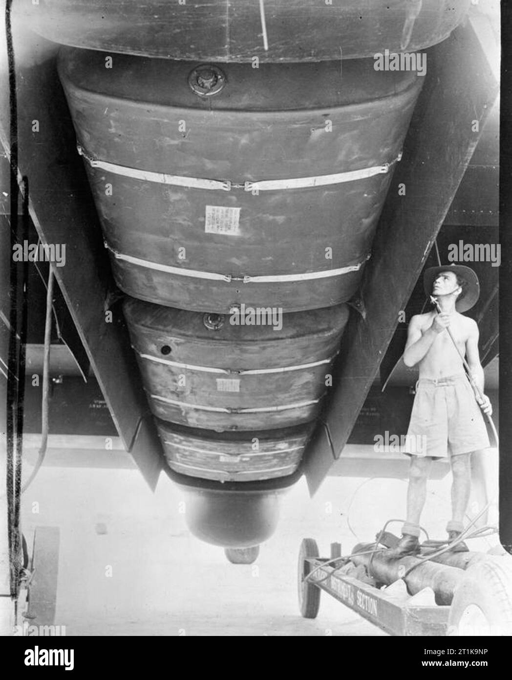 Royal Air Force in den Fernen Osten, 1941-1945. Die Bombe - Bucht von einem Handley Page Halifax B Mark III der Nr. 1341 (Radio Gegenmaßnahmen) Flug in Digri, Indien, eröffnet drei Bauch Kraftstoff - Tanks, installiert weiträumige Flüge über Südostasien untersucht Japanische Radar und Radiosendungen zu erleichtern. Auf der rechten Seite, führenden Aircraftmen E Campbell von Rutherglen, Schottland ist, lädt sich die Sauerstoffversorgung des Flugzeugs. Stockfoto