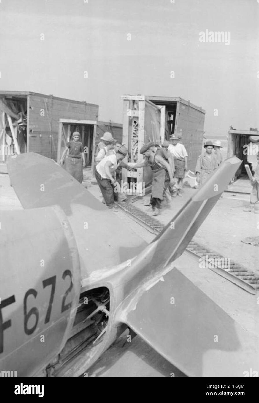 Operationen der Royal Air Force im Nahen Osten und Nordafrika, 1939-1943. Zivile Arbeiter, die den Flügel eines Supermarine Spitfire Mark VIII vor der Montage des Flugzeugs (JF672, im Vordergrund gesehen) durch die No.145 Maintenance Unit am Flughafen CazÃ, Casablanca, Marokko, aus der Kiste fuhren. Die meisten der in 145 MU beschäftigten Zivilisten waren spanische Flüchtlinge, die nach dem Sieg von General Franco im Bürgerkrieg nach Nordafrika flohen. Sie wurden von den Vichy-Franzosen inhaftiert, aber von den Alliierten im November 1942 freigelassen. Stockfoto