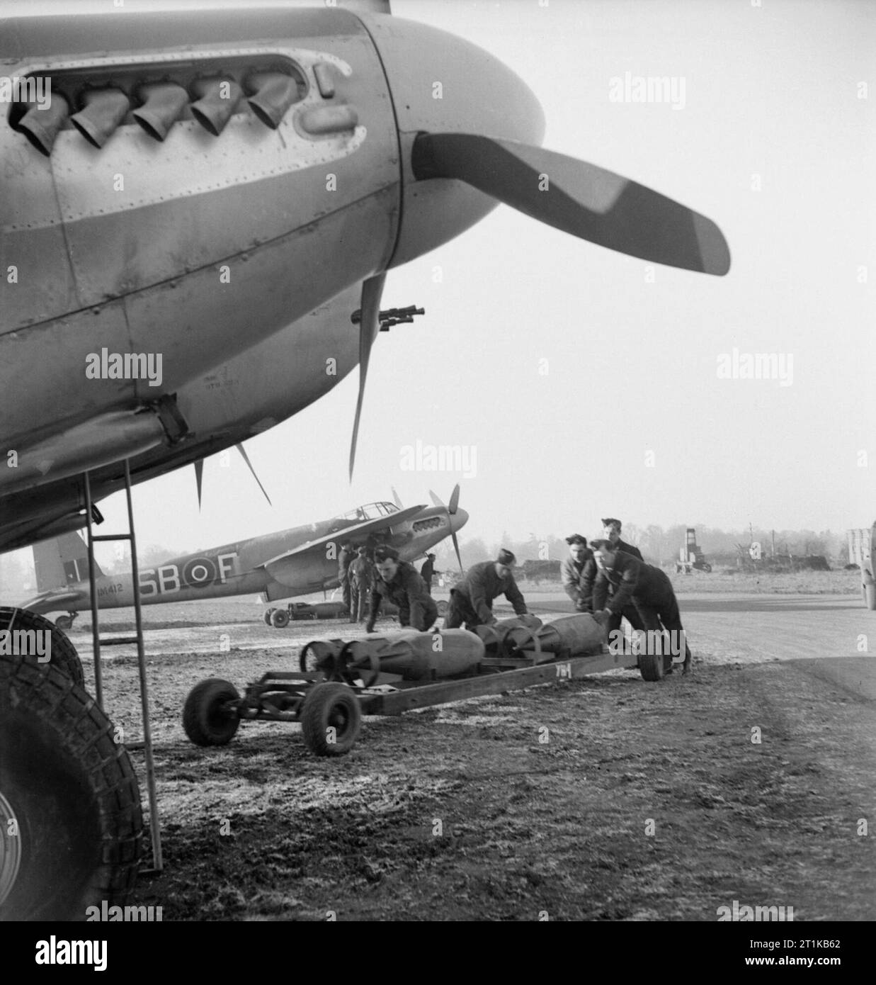 Royal Air Force - 2nd Tactical Air Force, 1943-1945. Waffenexperten wheeling trolleys von 500-lb MC Bomben zu De Havilland Mosquito FB Mark gegenüber von Nr. 464 Squadron RAAF in Hunsdon, Hertfordshire. Die weitere Flugzeuge, MM 412 B-F', überlebte den Krieg, um die jugoslawische Luftwaffe im Jahr 1952 verkauft werden. Stockfoto