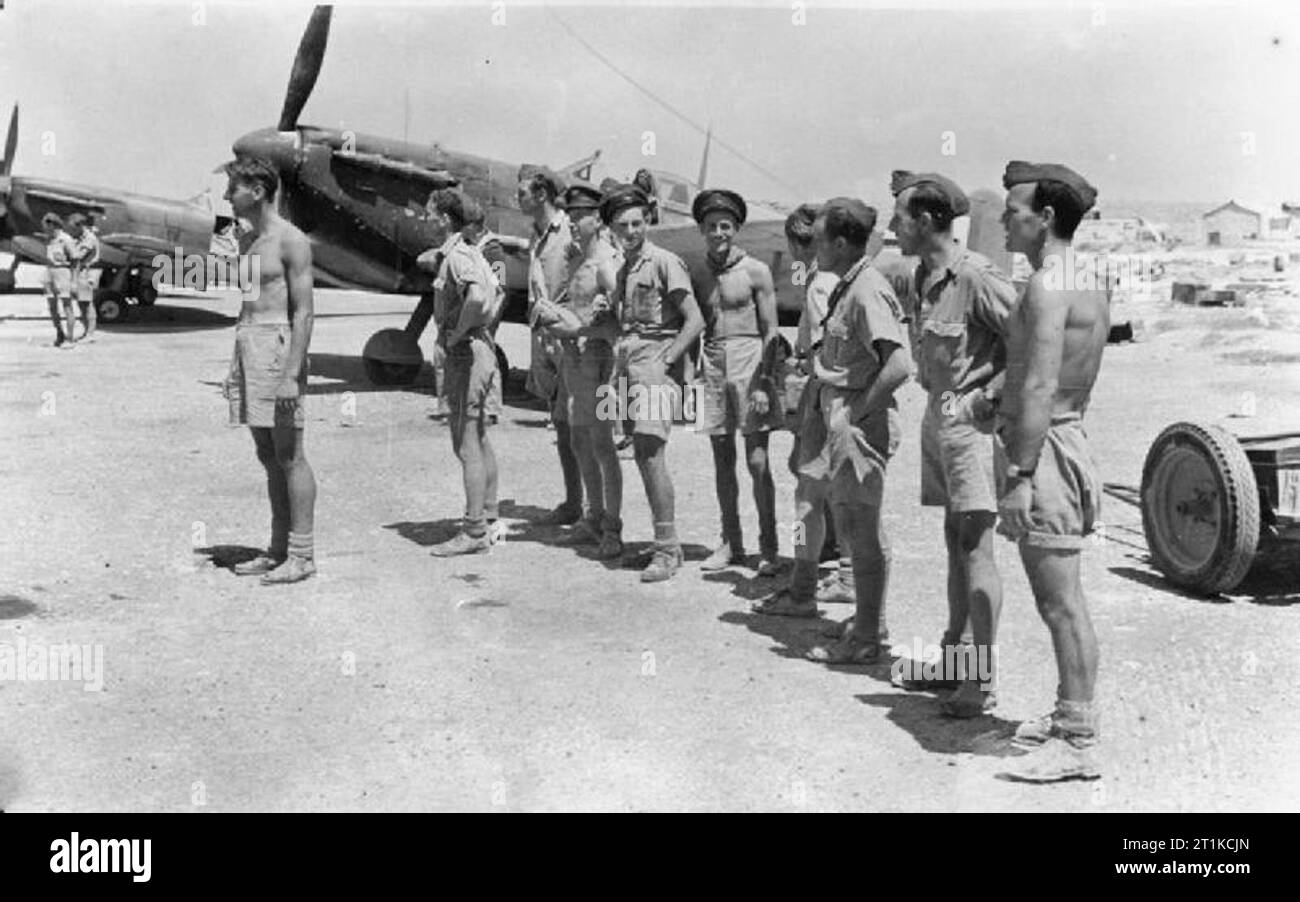 Royal Air Force - Operationen in Malta, Gibraltar und das Mittelmeer, 1940-1945. Bodenpersonal von Nr. 249 Squadron RAF eine Pause von der Pflege ihrer Supermarine Spitfire Mark VCs bei Ta Kali, Malta, die Aktivität auf dem Flugplatz zu beobachten. Stockfoto