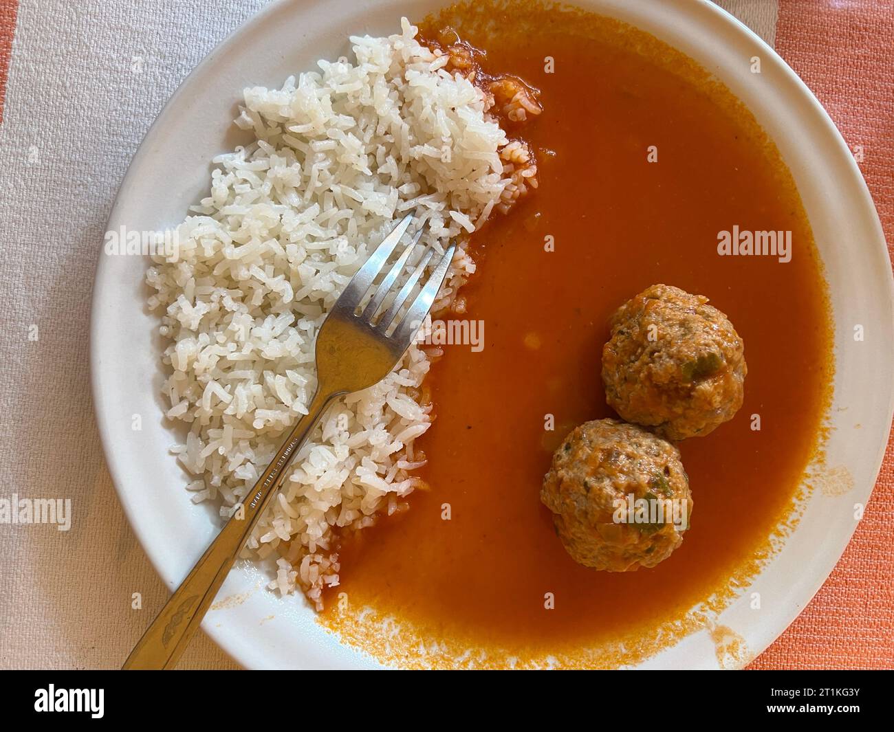 Teller Albondigas Fleischbällchen mit Tomatensauce und Reis mit einer Gabelschere von oben Stockfoto