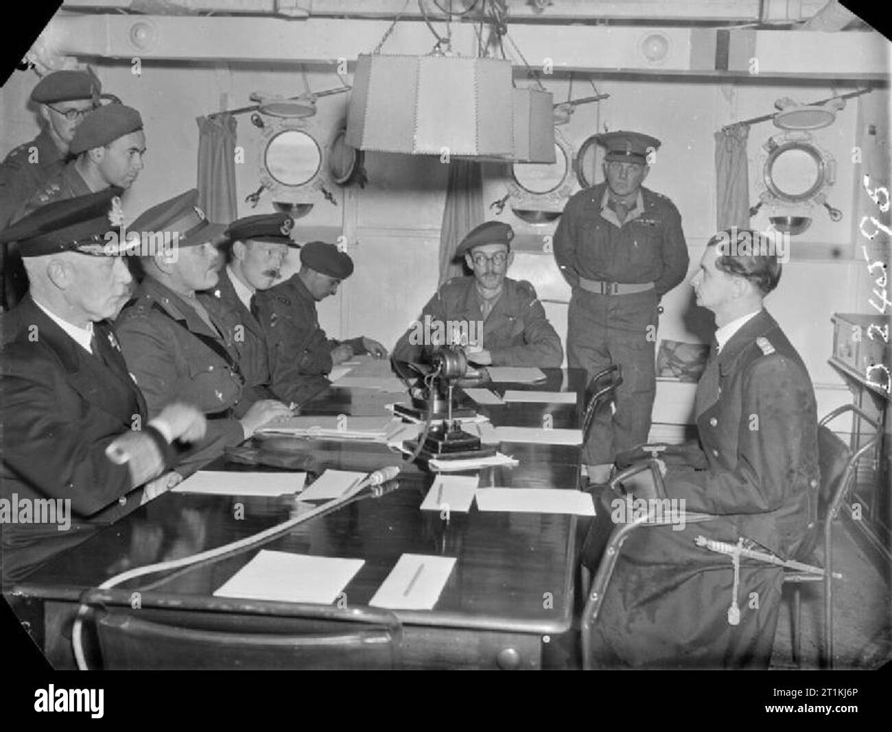 Kanalinseln befreit - das Ende der deutschen Besatzung, Kanalinseln, Großbritannien, 1945 Eine Szene an Bord der HMS BULLDOG während der ersten Konferenz mit Captain Leutnant Zimmerman vor der Unterzeichnung des Kapitulationsdokuments, das die Kanalinseln befreite. Von links nach rechts um den Tisch herum sind: Admiral Stuart (Royal Navy), Brigadegeneral A E Snow (Chief British Emissary), Captain H Herzmark (Geheimdienstkorps), Wing Commander Archie Steward (Royal Air Force), Leutnant Colonel E A Stoneman, Major John Margeson, Colonel H R Power (alle britische Armee) und Captain Leutnant Zimmerman (GE) Stockfoto