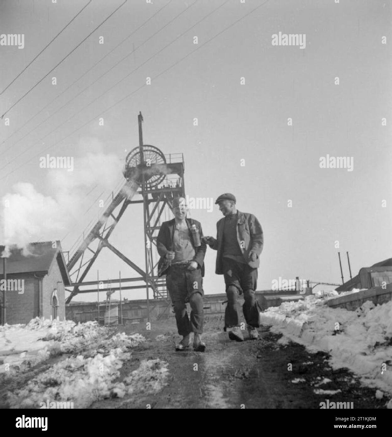 Bergarbeiter - Alltag in einem Midlands Colliery, England, UK, Bergarbeiter Ernest "König der Könige" 1944 Brooks (links) und George 'Napoleon' Station verlassen die Midlands Zeche wo Sie arbeiten nach ihrer sieben und eine halbe Stunde zu verschieben. Gemäß der ursprünglichen CAPTION,'ihre kombinierte Ausgabe ist fast so groß wie 3 Durchschnitt Männer. Zusammen bilden sie ein großartiges Team". Hinter ihnen, die Welle gewundenen Gang ist deutlich zu sehen. Stockfoto