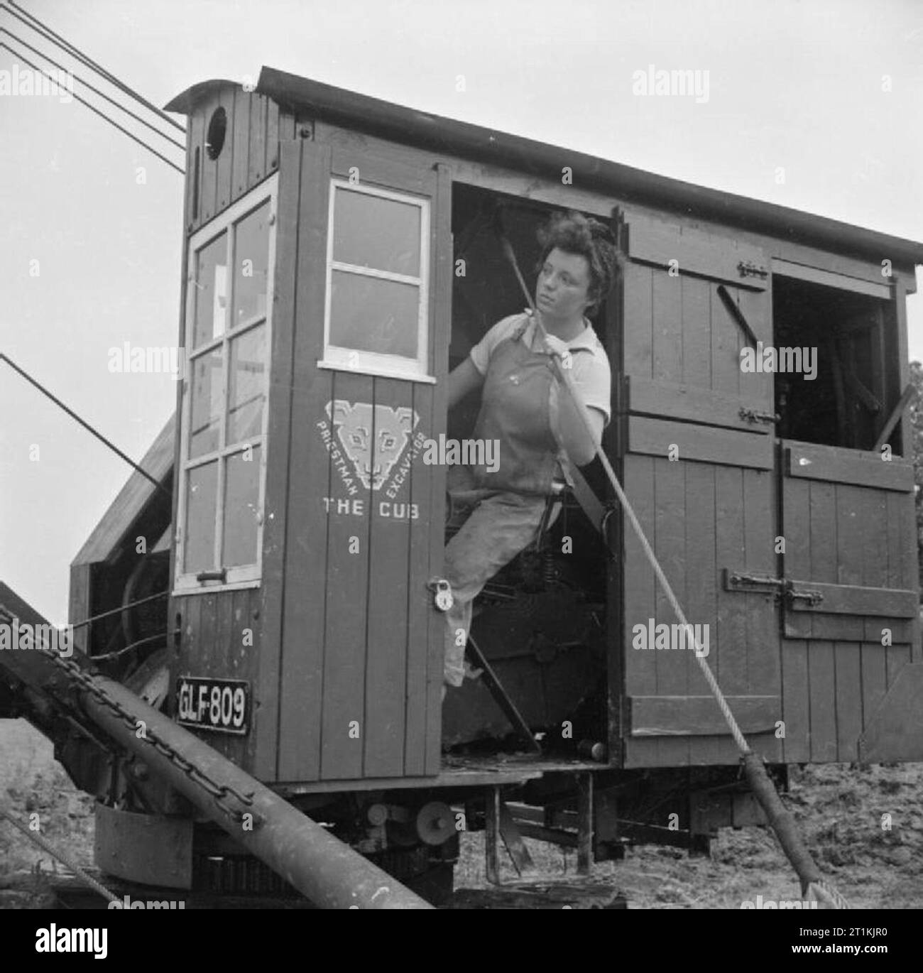 Entwässerung von Grundstücken - Vorbereitungen für Landwirtschaft, Clyst Sümpfe, Devon, 1942 ein Land Mädchen schaut aus der Tür der Kabine der großen Drag-line Bagger, der verwendet wird, Gräben drainage entlang dieses Land zu verbessern. Das Land wird dann für Kulturpflanzen zur Verfügung und Tiere zu weiden. Eine der Frauen ist etwas Verweisen auf andere. Land Mädchen waren meist beteiligt, der in diesem Zusammenhang in die Abflachung der Land. Stockfoto