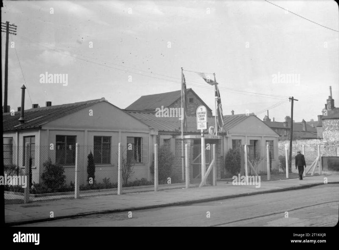 George Cross Club - Erholung und Entspannung für maltesische Seeleute in Cardiff, Wales, UK, September 1944 ein Blick auf das Äußere des neu eröffneten George Cross Club für maltesische Seeleute in Cardiff. Es war auf einer Bombe in Bute Street gebaut. Vor dem Eingang ist ein Zeichen, das lautet: "George Cross Club Hostel und Club für maltesische Matrosen", und der britische und der maltesischen Flags sind auf Pfählen auf beiden Seiten des Eingangs aufgehängt werden. Stockfoto