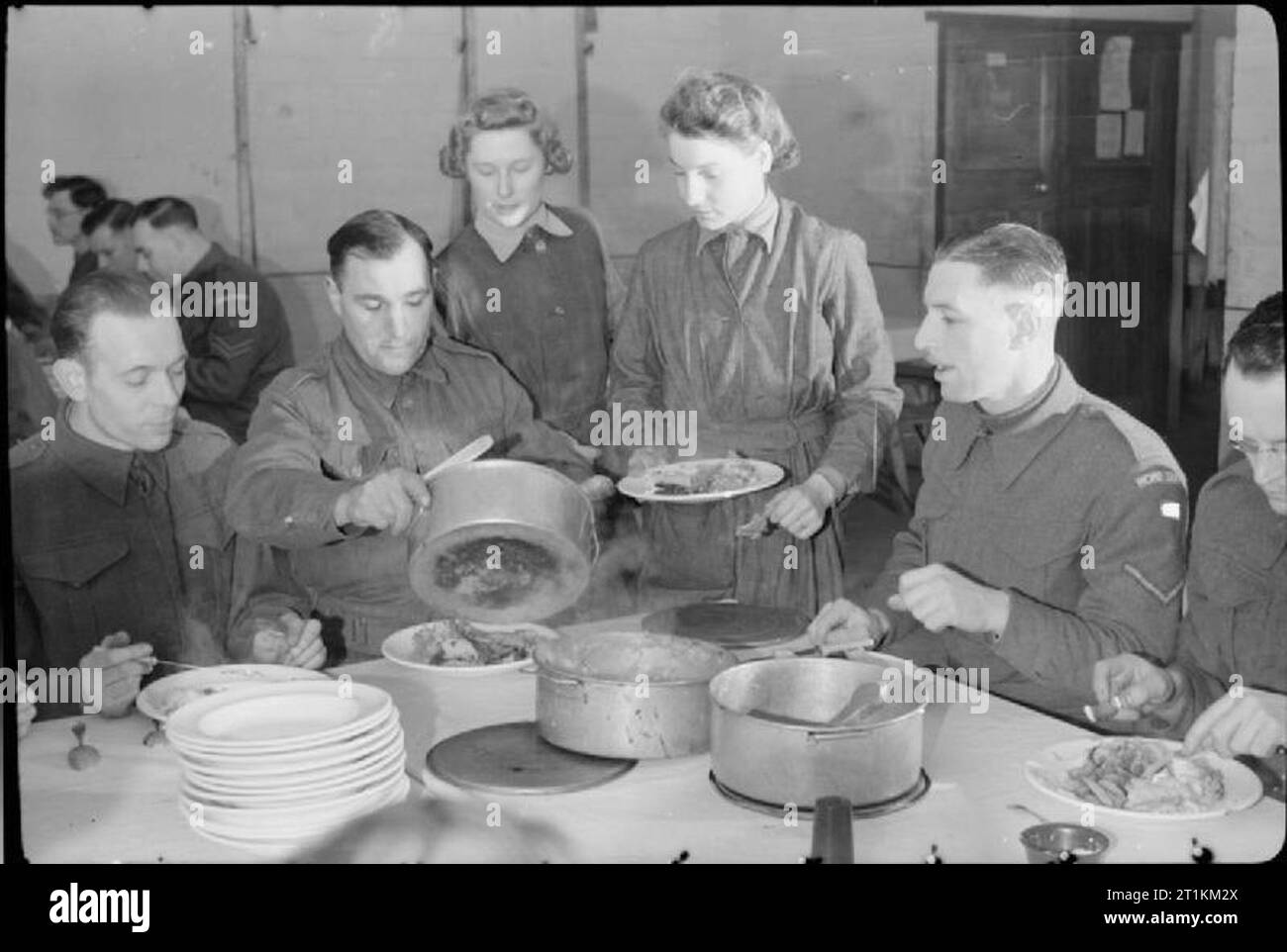 Home Guard Mann Anti-Aircraft Gun - Zivilschutz in Großbritannien, 1943 Frauen der Auxiliary Territorial Service (ATS) bringen das Essen für die Mitglieder der Home Guard, bevor sie ihren Nachtdienst beginnt Manning ein anti-aircraft (AA) Gewehr. Stockfoto