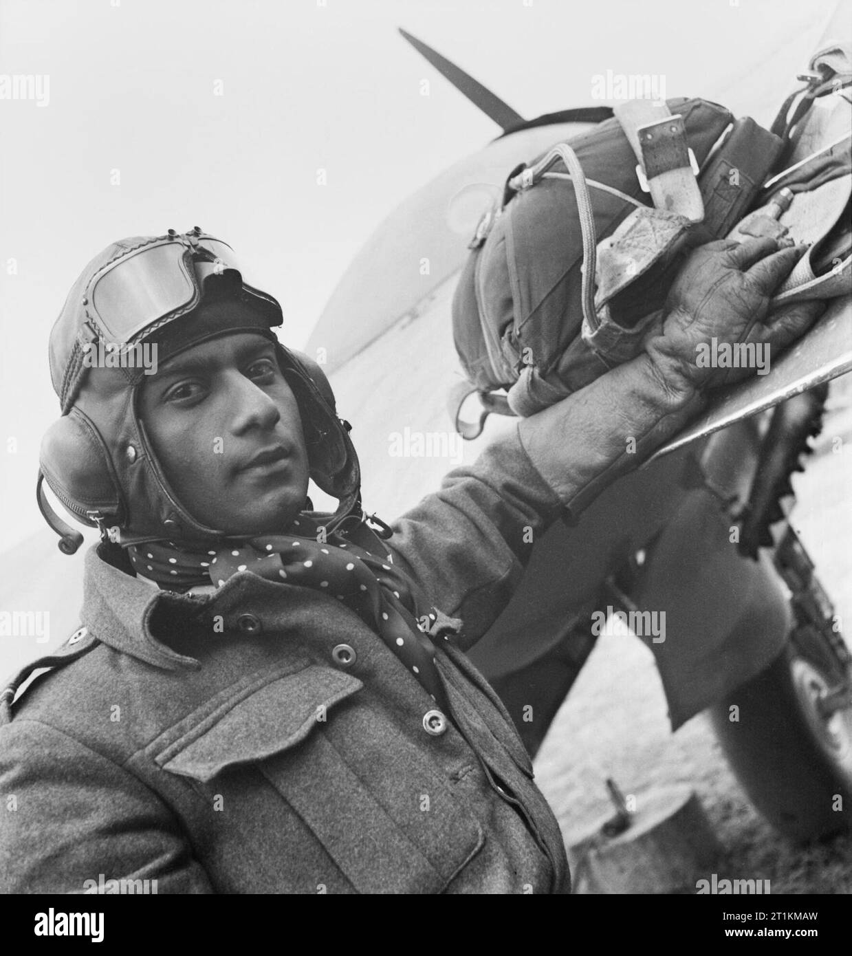 Indische Test Pilot, England, 1942 ein markanter Kopf und Schultern Portrait von Flying Officer P C Ramachandran tragen, Helm und Handschuhe, neben seinem Flugzeug, vor einem Testflug. Stockfoto