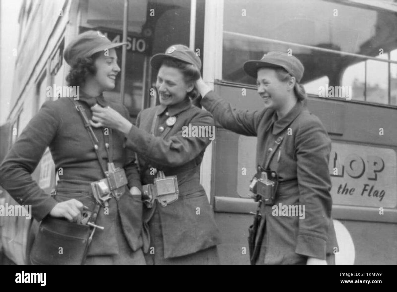 Die Londoner Busse in Kriegszeiten, England, London 1941 bus Leiter Lilian Menhenet, Louise Taylor und Marie Ellis teilen ein Witz, sie gehen aus, nach ihrer Schicht. Dieses Foto wurde wahrscheinlich im September 1941 übernommen. Stockfoto