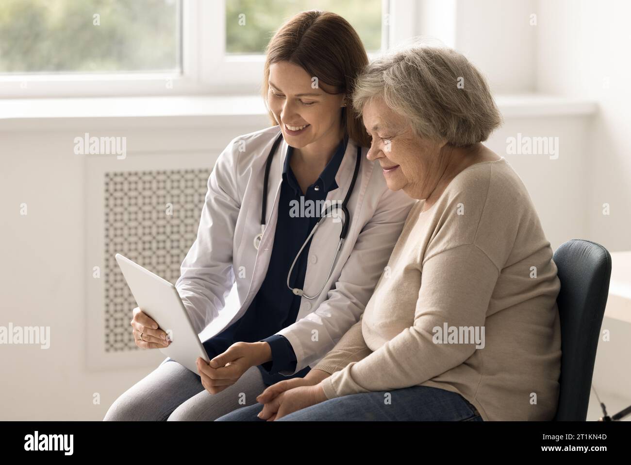 Therapeuten zeigen Gesundheitstests auf Tablette älteren Patienten Stockfoto