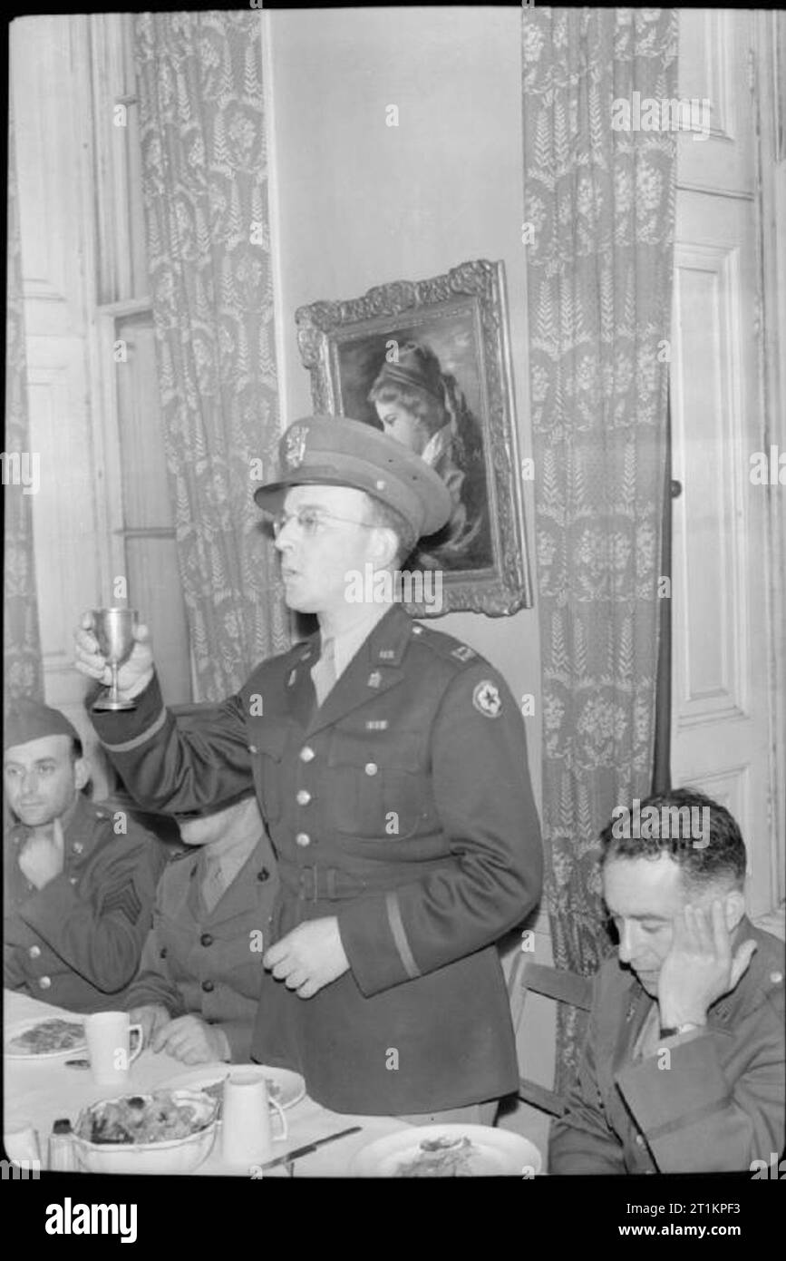 Die alliierten Streitkräfte Feiern das Jüdische Neue Jahr - religiöse Feiern im Balfour Service Club, London, UK, 1943 Kapitän Juda Nadich (stehend Mitte), ein Rabbi mit der amerikanischen Armee, hebt sein Glas, als er den Kiddusch Gebet bietet. Auf der linken Seite von Captain Nadich (ursprünglich aus Baltimore, Maryland), von seinen rechten Arm versteckt, ist Kapitän Gerson Levi, aus Montreal, Kanada, ein Rabbi mit der kanadischen Streitkräfte. Er hatte vorher das Gebet über das Brot angeboten. Rechts auf dem Foto ist Colonel Moses Strock aus Boston, Massachusetts. Stockfoto