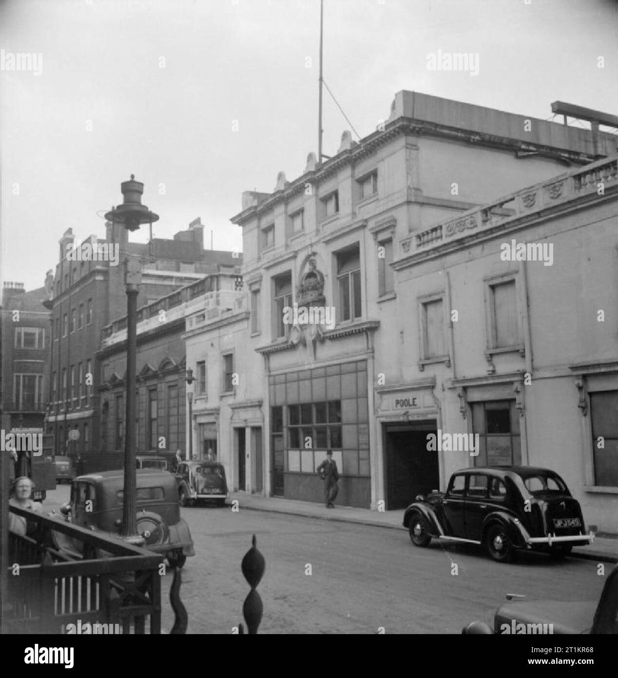 Savile Row - Tailoring bei Henry Poole und Co., London, England, UK, 1944 Ein Blick auf die Westseite der Savile Row, zeigt die beeindruckende Fassade der Henry Poole und Co Autos entlang der Straße geparkt und mehrere Fußgänger über ihr tägliches Geschäft gehen gesehen werden kann. Stockfoto