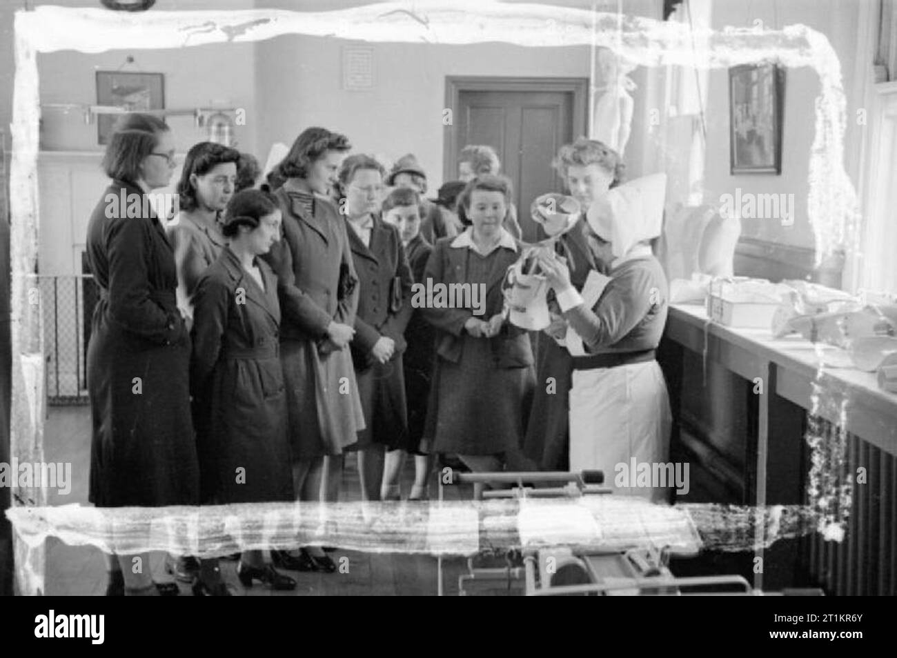 Schulmädchen in Krankenschwester - Medizinische Ausbildung in Großbritannien, 1942 Mädchen, die sich vor - die Ausbildung in der Krankenpflege in ihrem letzten Jahr der Grundschule hören zu einer Krankenschwester, als sie die Nutzung eines spinalen Ladestation auf ein Krankenhaus aufsuchen, als Teil ihrer Ausbildung verpflichtet zeigt. Stockfoto