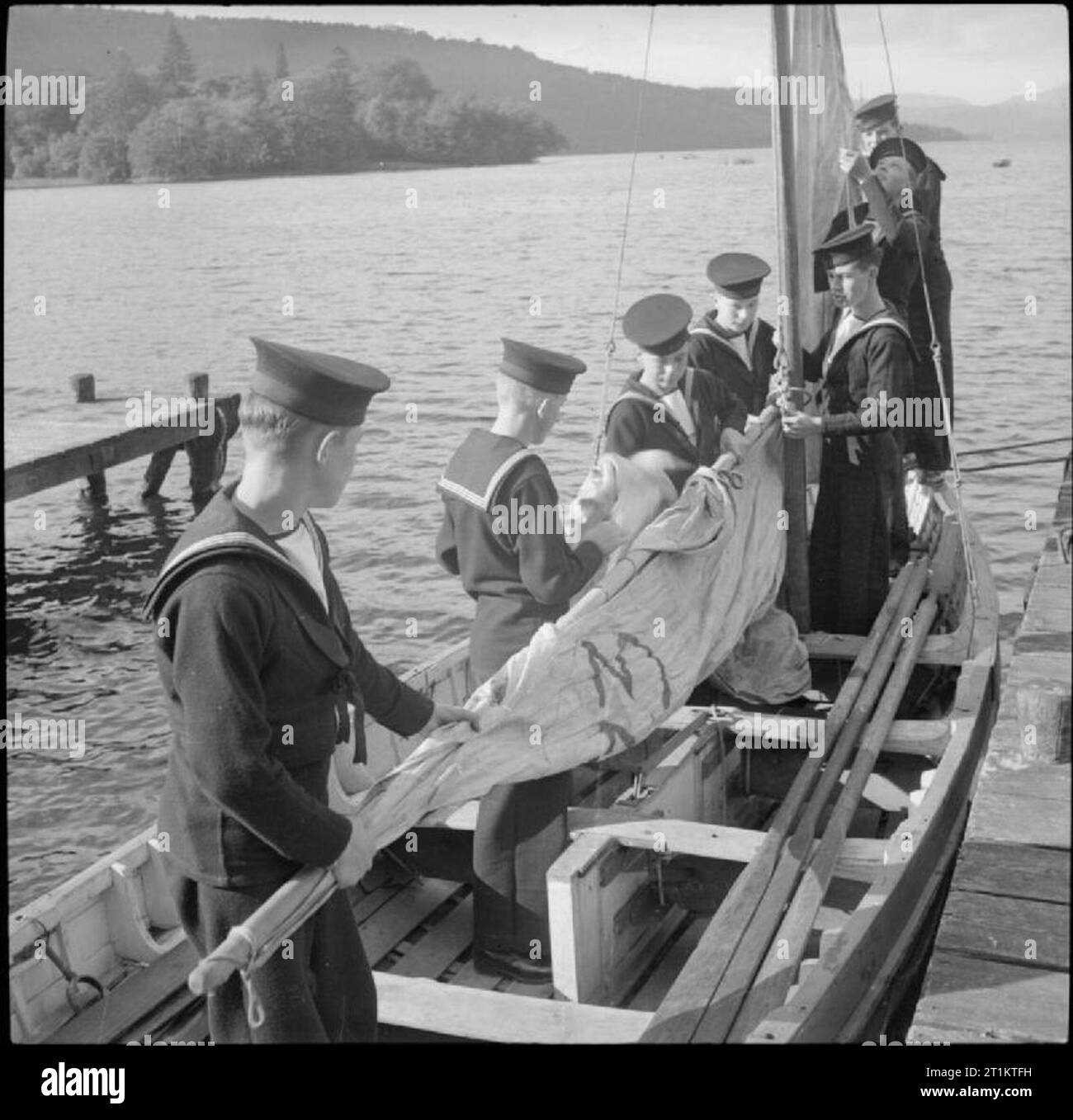 Sie lernen, Segler-Sea Cadet Training auf dem Schulschiff HMS Undine, Bowness-on-Windermere, England, UK, 1943 In den späten Sommer Sonnenschein, Jungen auf das Meer Kadetten Korps bereit, die Segel von einem walfänger auf dem Wasser des Lake Windermere im Rahmen ihrer Ausbildung an der HMS UNDINE. Stockfoto