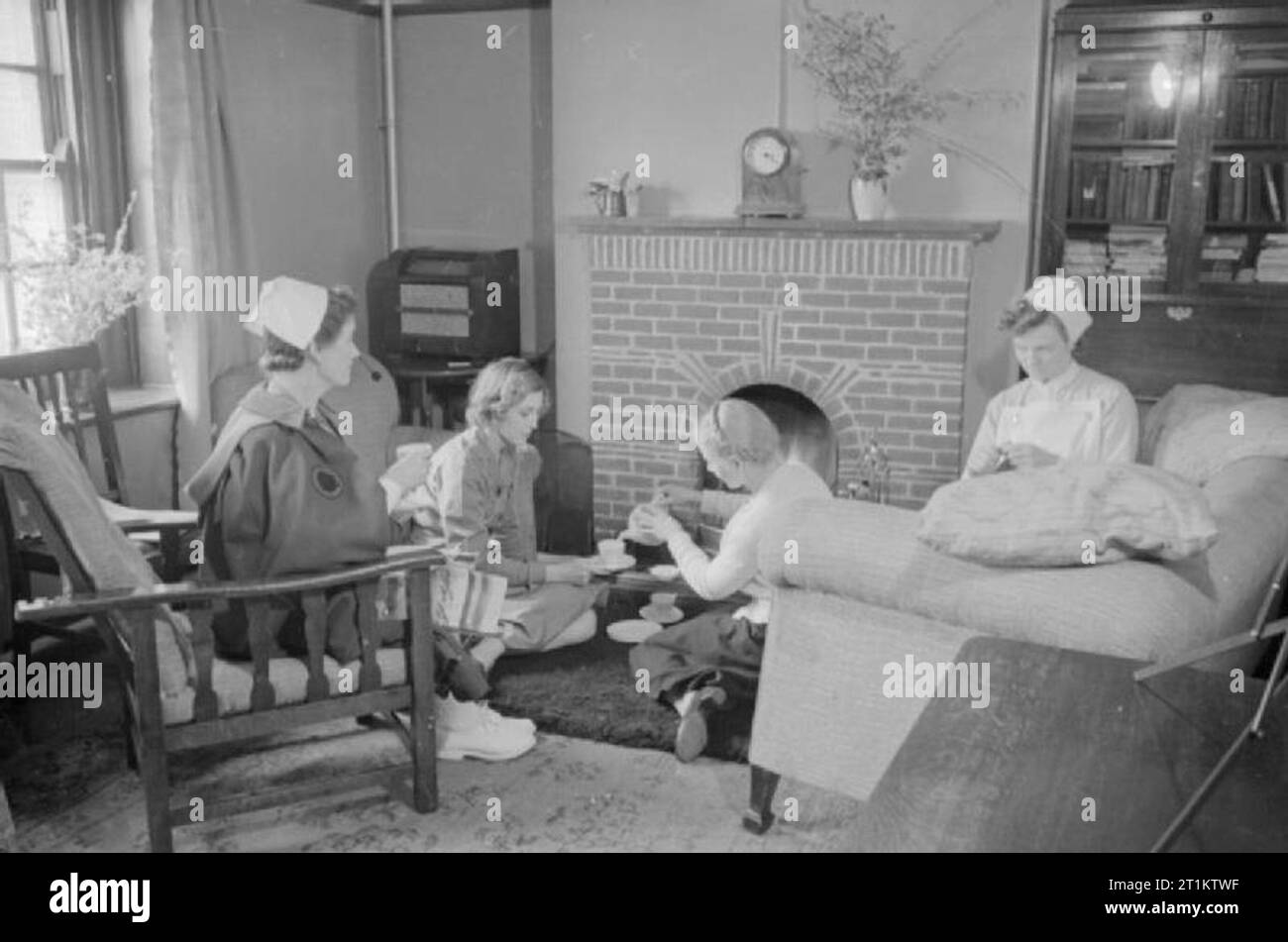 Eine amerikanische Krankenschwester in Großbritannien - die Arbeit von Schwester Trotter im Park Prewett Krankenhaus, Basingstoke, England, 1941 Schwester Trotter (zweiter von links) genießt eine Tasse Kaffee mit Kollegen in der Lounge der Krankenschwester im Park Prewett Krankenhaus in Basingstoke. Ihre Kollegen sind, von links nach rechts, Schwester Bertha Fall, eine englische Krankenschwester aus der Amerikanischen Krankenhaus in Paris, ist nun ein Mitglied der Amerikanischen Krankenhaus in Großbritannien (AHB); Fräulein N Russell (Gießen der Tee) ist eine US-amerikanische Krankenschwester in Bellevue Hospital, New York; und Schwester Radcliffe ausgebildet ist eine englische Krankenschwester aus St Thomas's Hospital in London. Stockfoto