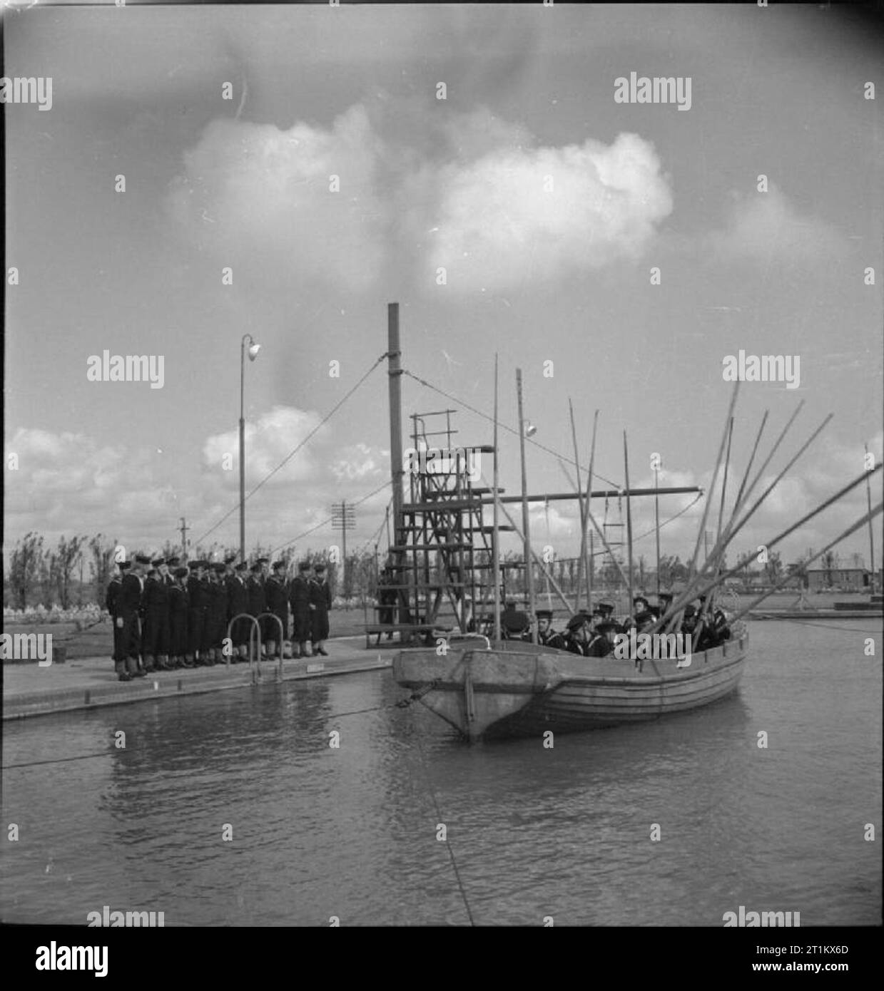 Belgische Segler auf eine Skegness Trainingslager - Belgische Naval Training an Butlin's, Skegness, Lincolnshire, England, Großbritannien, 1945 eine Gruppe von neuen Rekruten nehmen an einem Boot bohren an HMS ROYAL ARTHUR, Skegness. Die Hälfte der Gruppe am Pool bleiben, während die andere Gruppe sind im Boot, Ruder angehoben. Vor dem Krieg, diese Ausbildungsstätte war ein Butlins Holiday Camp. Stockfoto