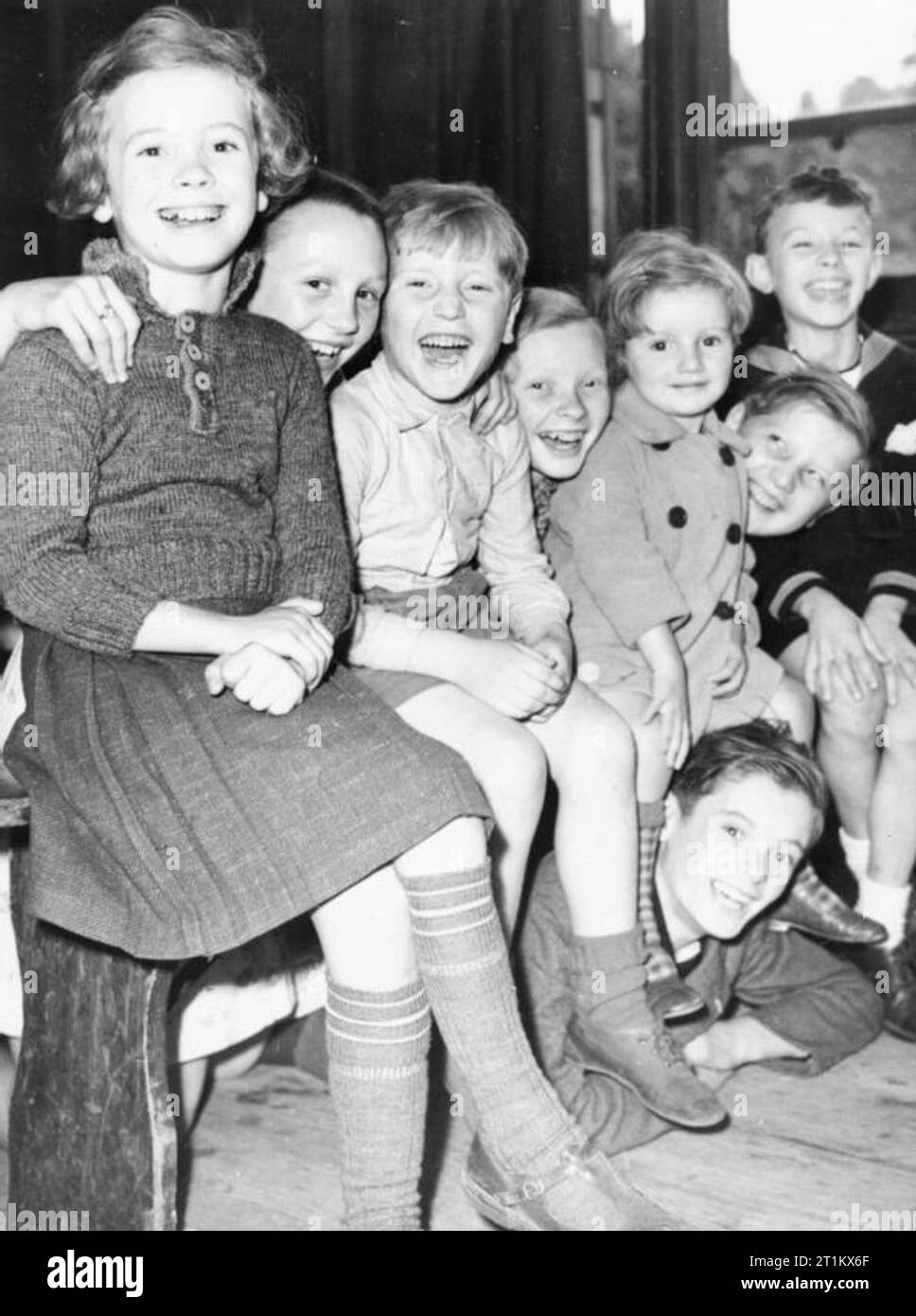Belgische Flüchtlingskinder in London, England, 1940 eine Gruppe von acht Jungen belgischen Flüchtlinge Lächeln für die Kamera auf Ihre billet, irgendwo in London. Stockfoto