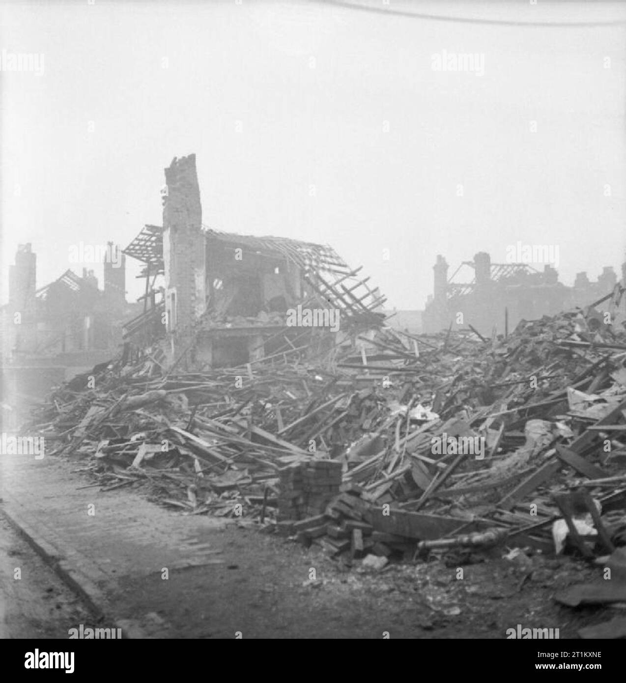 Bombenschäden in Birmingham, England, 1940 nur eine sehr stark beschädigten Haus noch steht inmitten der riesigen Haufen von Holz und Bauschutt nach einem Luftangriff auf Queen's Road, Aston, Birmingham. Diese Seite wurde während der längsten Raid von Birmingham nachhaltig beschädigt, Dauer 13 Stunden, die am 11. Dezember 1940 eingetreten ist. Ein paar andere Häuser können im Hintergrund gesehen werden: alle sind ohne Dach. Stockfoto