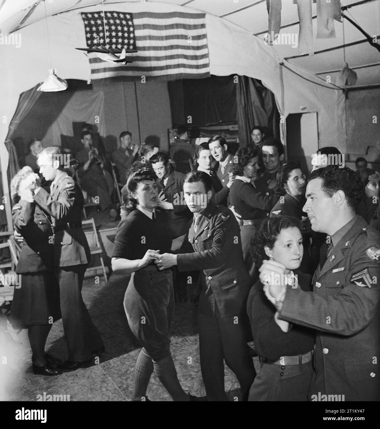 British Land Armee Mädchen und Mitglieder des Women's Royal Air Force (WAAF) Tanz mit Männer der US Army Air Force 8 in Suffolk während 1943. British Land Armee Mädchen und Mitglieder des Women's Royal Air Force (WAAF) Tanz mit Männer der US Army Air Force 8 in Suffolk während 1943. Stockfoto