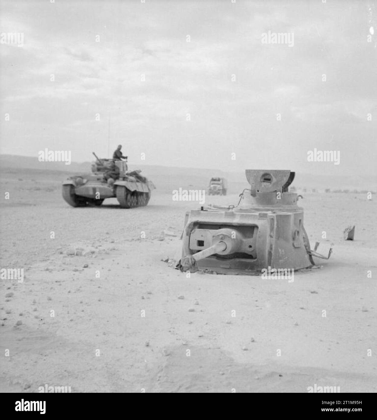 Der britischen Armee in Nordafrika 1942 Der geschützturm eines Matilda Tank, gefangen genommen worden war und in der Position als Teil der Verteidigung von Halfaya Pass, 16. März 1942 verwendet werden betoniert. Ein Valentine Tank passiert im Hintergrund. Stockfoto