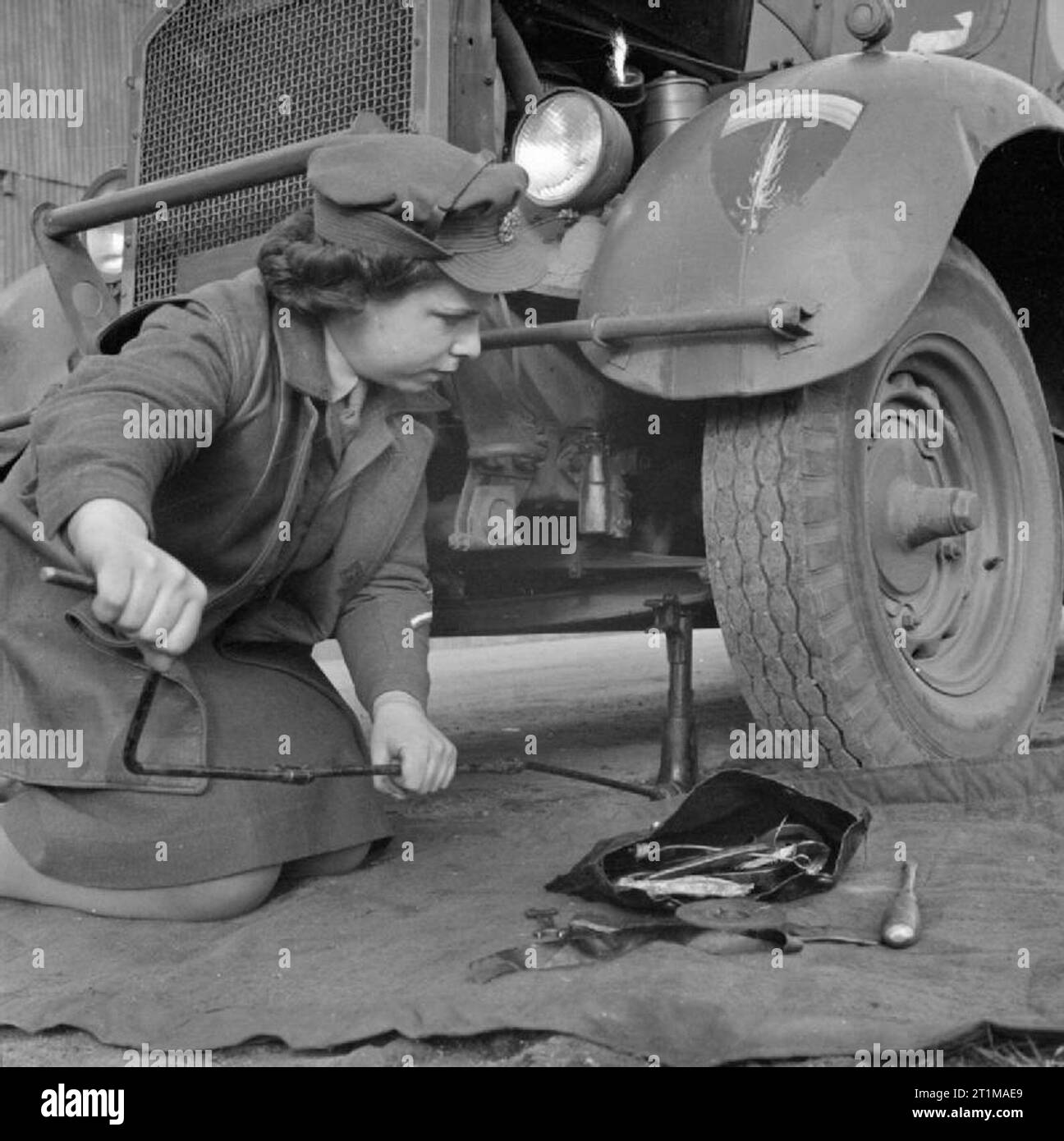 Die britische Armee in Nord-West-Europa 1944-45 Pte Maria Howis, ein Mitglied der ATS bei Supreme Headquarters Allied Expeditionary Force, Aufbocken eines Personal Auto im MT-Workshops, vom 3. Januar 1945. Hinweis Die SHAEF Abzeichen am Kotflügel des Fahrzeugs. Stockfoto