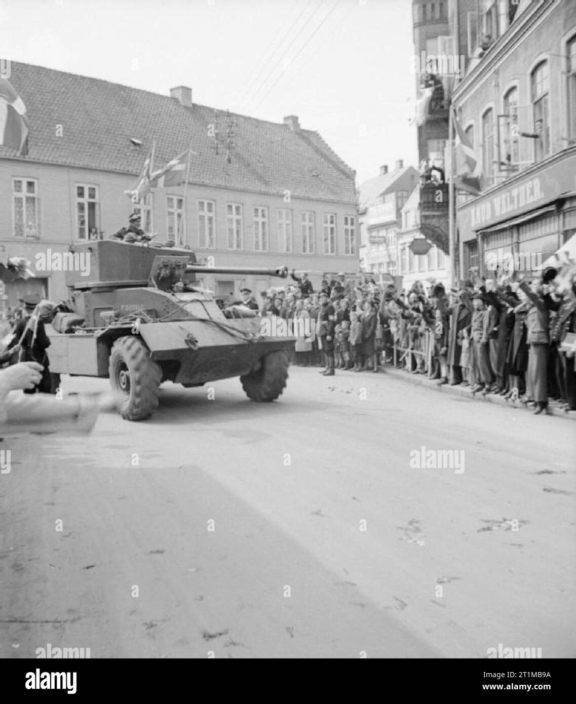 Die britische Armee in Nord-West-Europa 1944-45 ein AEC Panzerwagen wird von Zivilisten jubelten, als es eine dänische Stadt betritt, 8. Mai 1945. Stockfoto