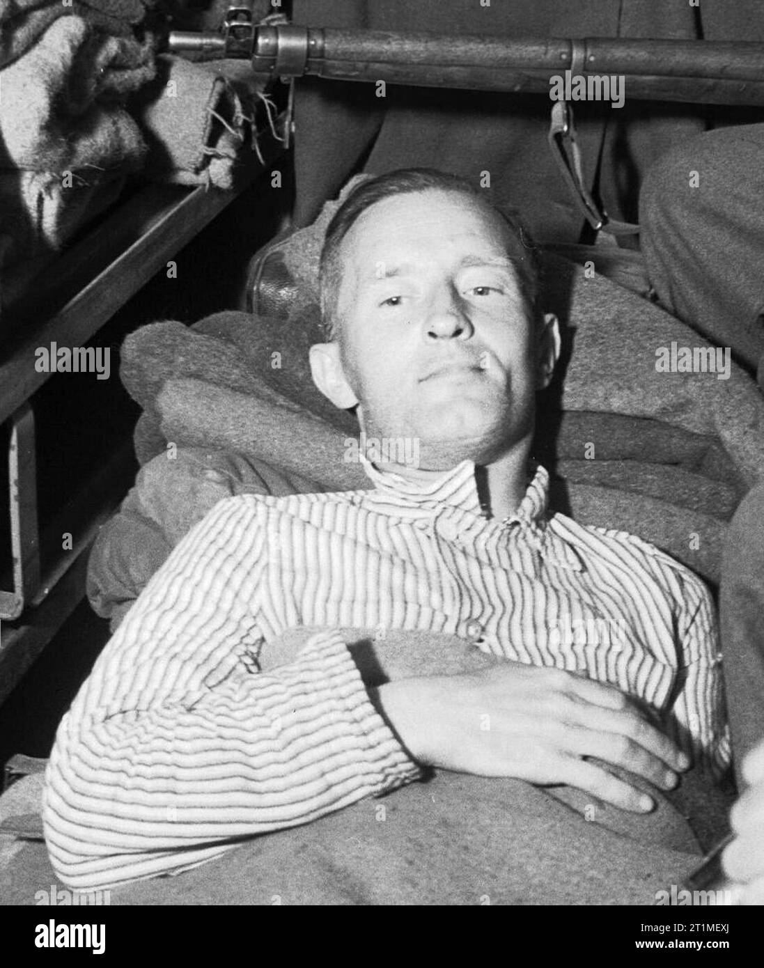 Die Gefangennahme von William Joyce, Deutschland, 1945 William Joyce liegt in einem Krankenwagen unter bewaffneter Bewachung, bevor er vom britischen Hauptquartier der 2. Armee ins Krankenhaus gebracht wird. Er wurde zum Zeitpunkt seiner Verhaftung in den Oberschenkel geschossen. Gaeilge: William Joyce ina lui in otharcharr, tar éis a gabháil. ?????? : ?????? ????? ????? ??? ?? ??? ???? ?? ?????? ??? 1945. ????: ?? ????? ????? ??? ?????? ?? ?????? ??? 1945 Stockfoto