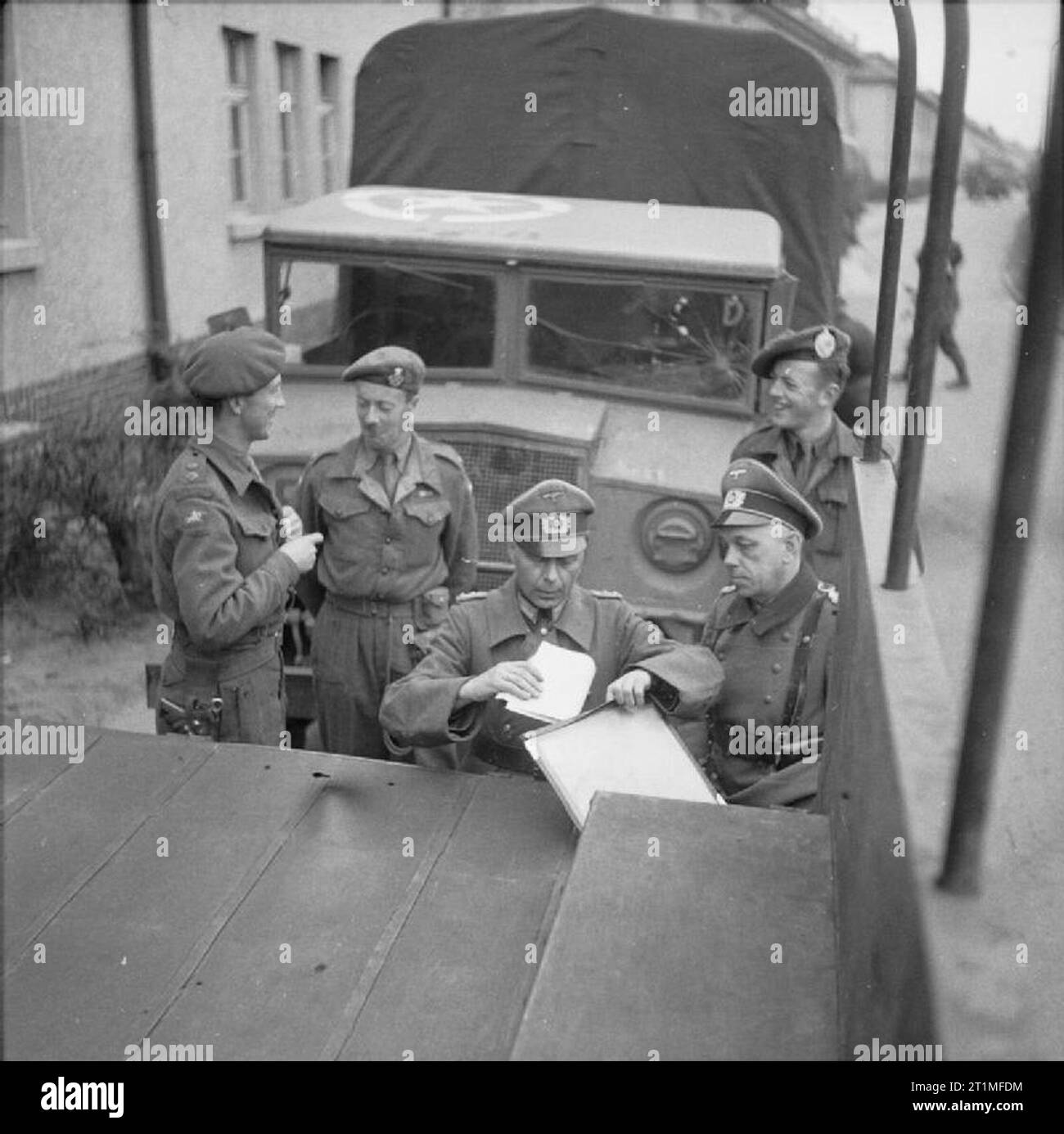 Die Befreiung der Konzentrationslager Bergen Belsen, April 1945 Oberstleutnant R I G Taylor (links) von 63 Anti Tank Regiment Royal Artillery, der erste britische Einheit Belsen und die deutschen Offiziere der Wehrmacht Truppen im Lager Vereinbarungen abzuschließen für die Deutsche Wehrmacht Truppen auf ihre Zeilen am Ende des vorübergehenden Waffenstillstand zurückzukehren zwischen deutschen und britischen Streitkräfte am 12. April 1945 vereinbart. Stockfoto