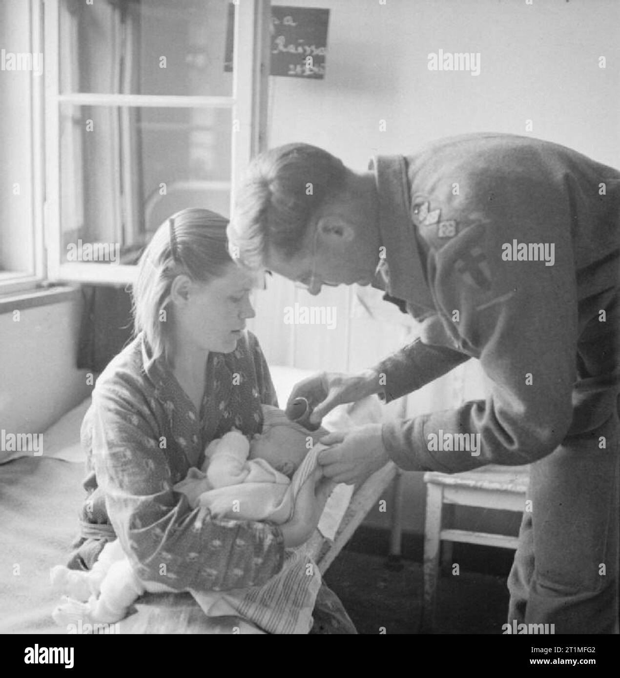 Die Befreiung der Konzentrationslager Bergen Belsen, Juni 1945 Vater Vincent Fay, eine britische Armee Kaplan des 9. britischen General Hospital, tauft ein Baby, Henji Dorochova, die in Belsen geboren wurde. Das Baby wird von seiner Mutter, Raissa aus Voroshilovgrad in der Ukraine statt. Während der britischen Hilfsaktion, neue Mütter wurden gefragt, ob sie wollten ihre Babys getauft zu werden, und wenn ja, unter welcher Konfession. Stockfoto