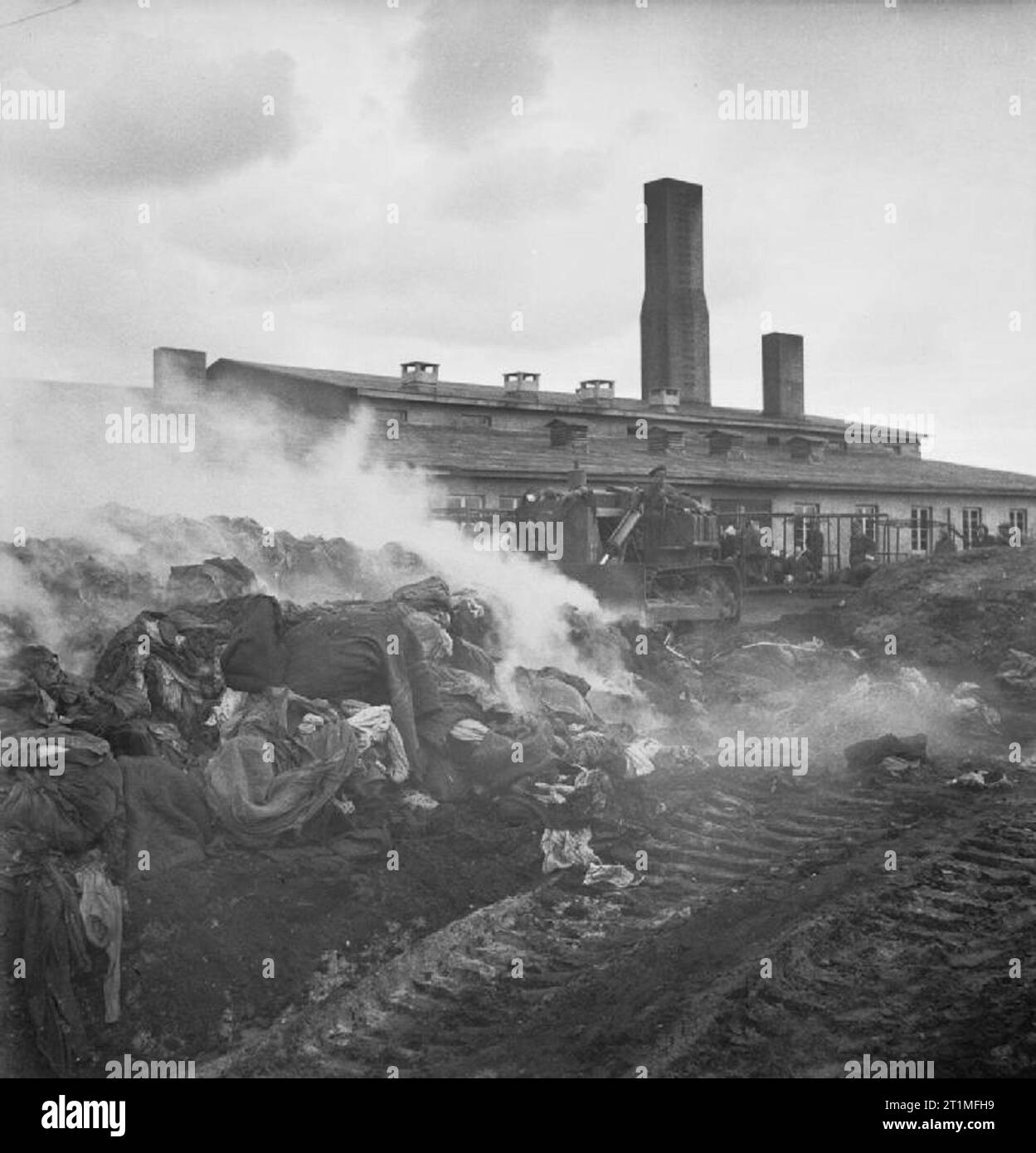 Die Befreiung der Konzentrationslager Bergen Belsen, Mai 1945 Stapel von Läusen befallene Kleidung sind verbrannt und dann durch Bulldozer begraben, um die Verbreitung der Krankheit zu stoppen. Stockfoto