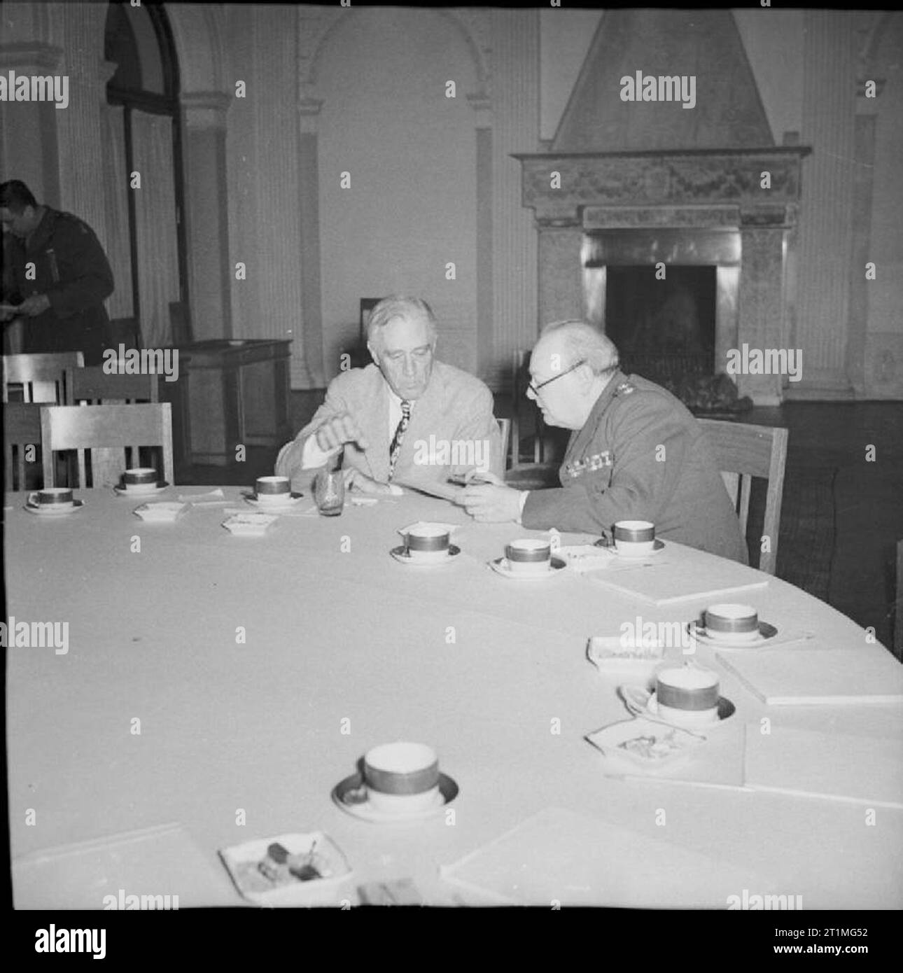 Die Konferenz von Jalta, Februar 1945 Präsident Roosevelt und Winston Churchill sind tief in der Diskussion, wie Sie an den großen runden Tisch im Konferenzraum sitzen, nach dem Treffen. Leere Kaffeetassen können auf dem Tisch gesehen werden. Die anderen Delegierten auf der Konferenz haben den Raum verließ. Stockfoto