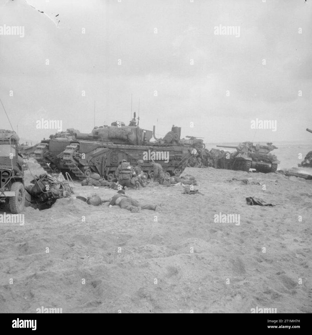 D-Day - britische Truppen während der Invasion in der Normandie am 6. Juni 1944 Mediziner an im Lee eines Churchill AVRE vom 5 Assault Regiment, Royal Engineers, auf Queen Beach verletzt, Schwert, 6. Juni 1944. Eine M10 Wolverine 3-Zoll-selbst-gun aus 20 Panzerabwehr: Regiment angetrieben im Hintergrund gesehen werden kann. Stockfoto