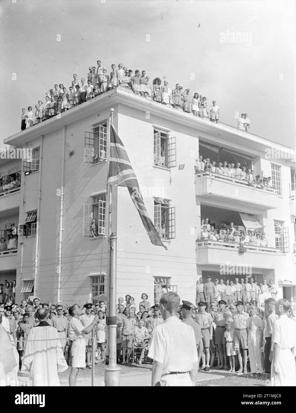 Im Fernen Osten, Singapur, Malaysia und Hong Kong 1939-1945 Befreiung und Rückführung - August 1945: Der Union Jack ist in Stanley Internierungslager, Hongkong, beobachtet von den Internierten angehoben. Stockfoto