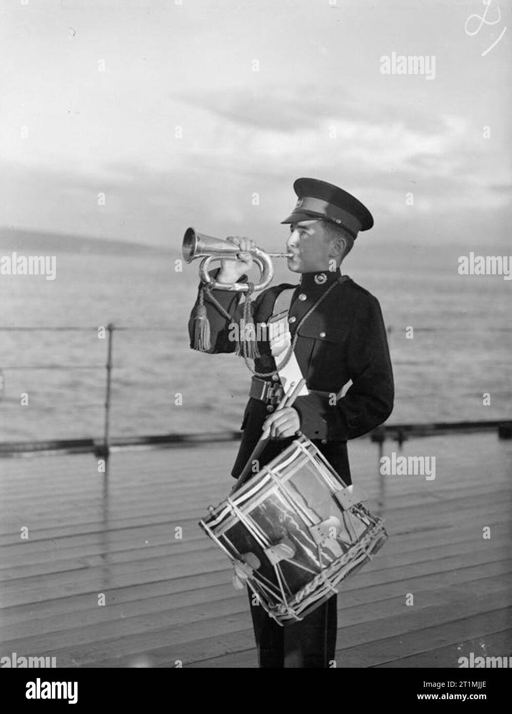 Die Royal Marines. Mit der Royal Marines der Home Fleet, Oktober und November 1942. R J D Rowe, eine 15-jährige Marine Hornist klingt der "noch", die alle Offiziere und Soldaten bringt auf dem oberen Deck des HMS Howe zu Aufmerksamkeit wie die Farben gehisst sind. Stockfoto