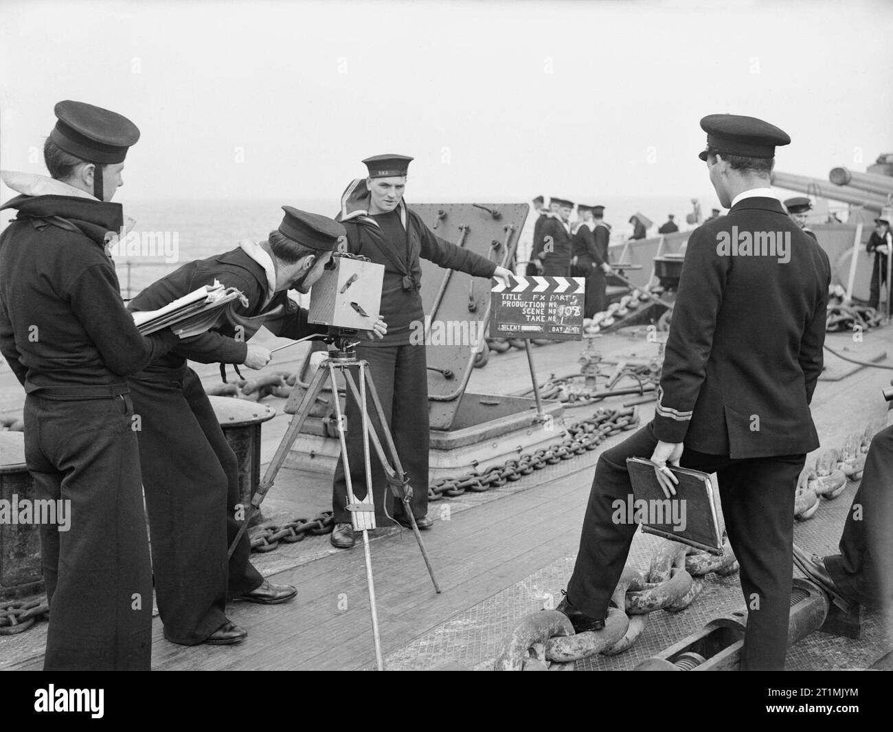 Die Royal Navy während des Zweiten Weltkrieges die Royal Navy Instructional Film Gerät wird für Maßnahmen an Bord eines Schiffes bereit. Ein naval Bewertung verwendet eine Kamera auf einem Stativ, während ein anderer hält eine Klappe für den Beginn einer nehmen. Ein Offizier und ein weiteres Rating halten einen Ordner und Ablagen der Noten. Stockfoto