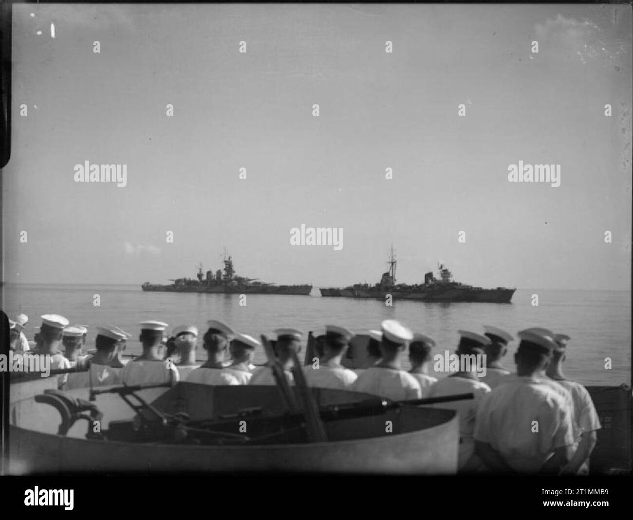 Die Royal Navy während des Zweiten Weltkriegs nach einem Rendezvous an der nordafrikanischen Küste, einen italienischen Kreuzer und einem LITTORIO Klasse Schlachtschiff Dampf langsam hinter der britischen Begleitung von Schiffen in Richtung Malta zu übergeben, alle zusammen, es gab zwei Schlachtschiffe, fünf Kreuzern und vier Zerstörern. Segler von HMS Warspite stehen im Vordergrund. Sie wurden auch durch Einheiten der britischen Zerstörer Flottillen begleitet sowie die schlachtschiffe Valiant und WARSPITE (von dem dieses Foto wurde aufgenommen). Stockfoto