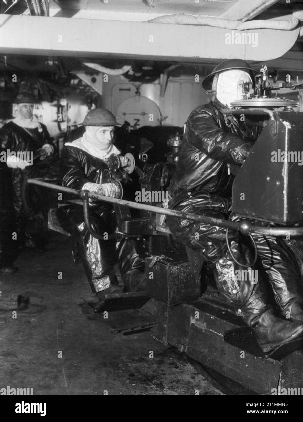 Die Royal Navy während des Zweiten Weltkriegs das Tragen von Anti flash Gang S Bell, der Thornaby, Yorks (der Torpedo Trainer) links, und J Beck, Wakefield, an ihrer Aktion Stationen am Torpedorohre an Bord der HMS JAMAICA bei Scapa Flow nach dem Untergang der Deutschen Kriegsschiffe, die scharnhorst am 26. Dezember 1943. Stockfoto