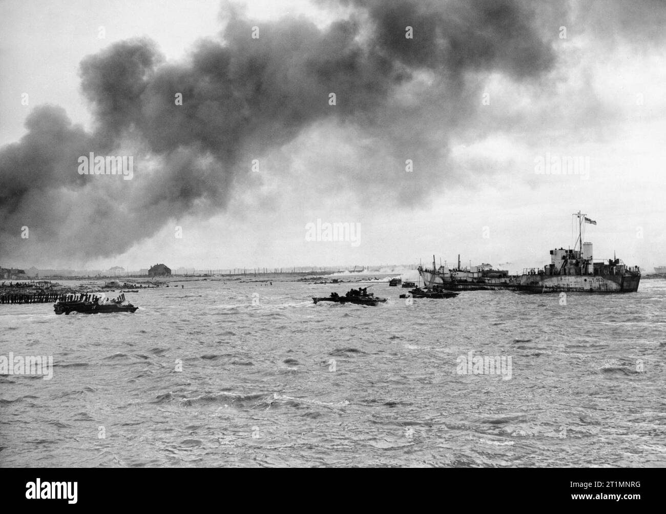 Die Royal Navy während des Zweiten Weltkriegs DUKWs oder 'DUcks "ply ihren Weg zwischen dem Strand und einer Landing Craft Tank (LCT 952) während der Landung durch Royal Marine Commandos auf der Insel Walcheren in Westkapelle, der westlichste Punkt der Insel, während der letzten Phase der Schlacht der belgischen Hafen von Antwerpen zu befreien. Der dunkle Rauch hängt in der Luft, während, was scheint, die Reste zu einer Rauch Bildschirm Verweilen am Strand ist. Stockfoto