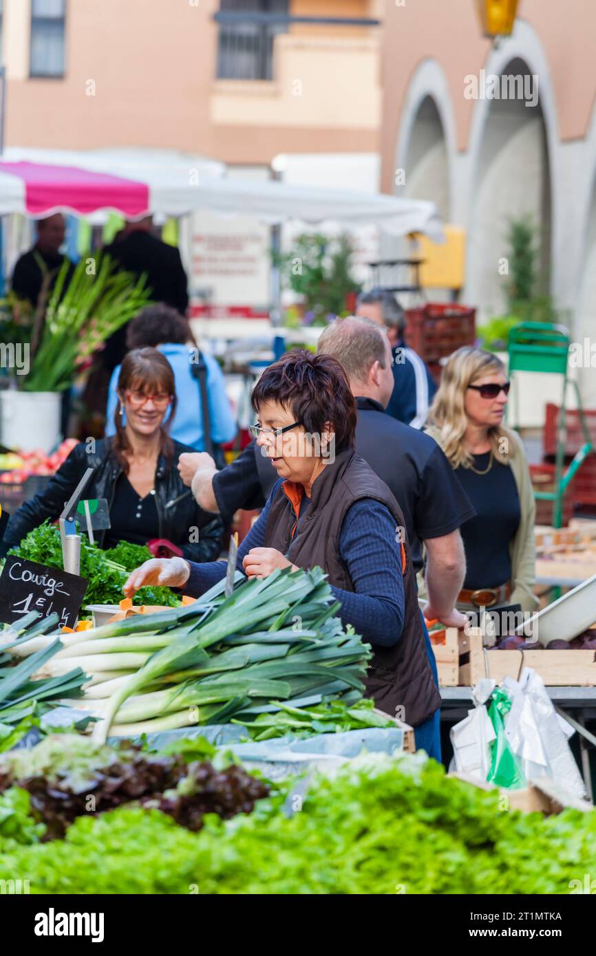 Eine französische Ladenhalterin pflegt ihr frisches Gemüse und Gemüse auf dem Lebensmittelmarkt in der Altstadt von Annecy, Frankreich Stockfoto