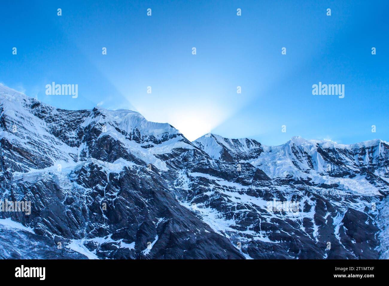 Erste Sonnenstrahlen hinter Grand Barrier im Himalaya, Annapurna Range, Nepal. Verschneite Himalaya Berge Sonnenaufgang. Stockfoto