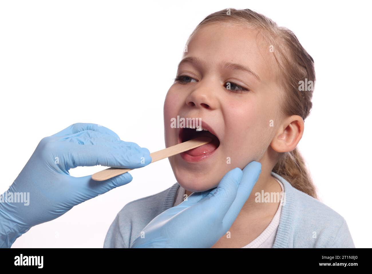 Arzt untersucht die Mundhöhle eines Mädchens mit Zungendepressor auf weißem Hintergrund Stockfoto