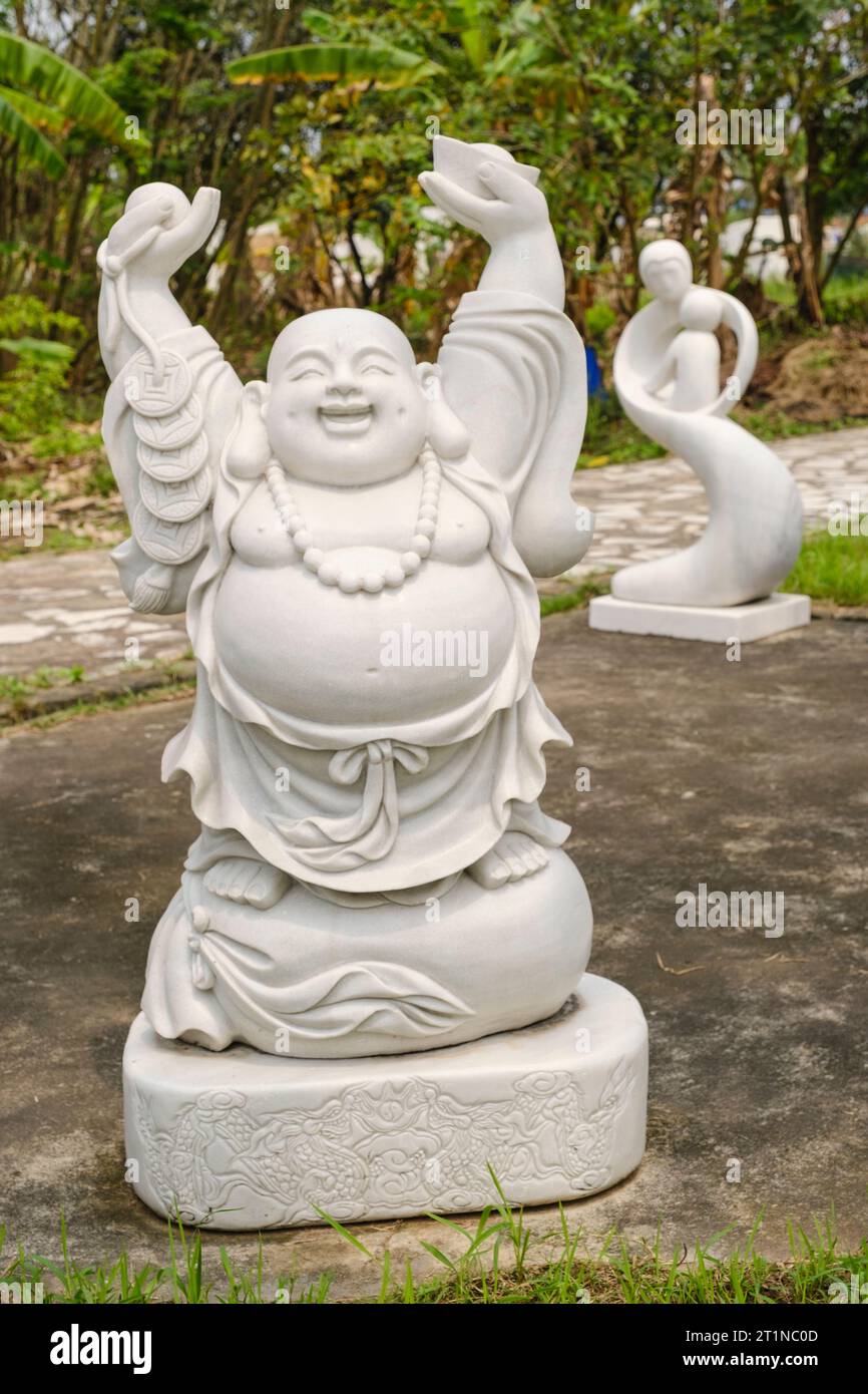 Lächelnde Buddha-Skulpturen, Vietnam, zwischen Hanoi und Haiphong, Highway QL18. Symbol für Glück, Fülle, Zufriedenheit und Wohlbefinden. Stockfoto