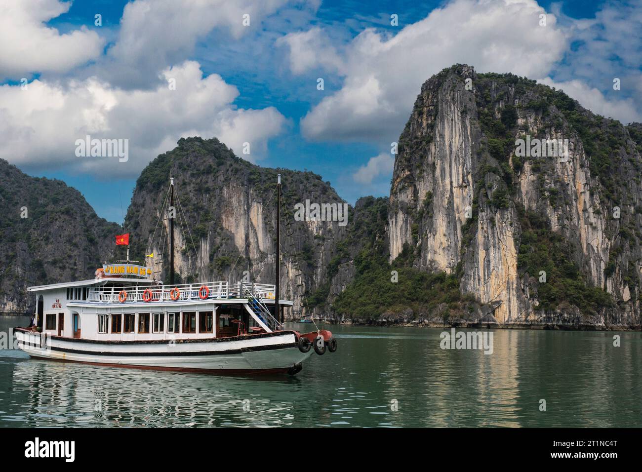 Ha Long Bay, Vietnam. Touristen Sightseeing Boot, Kalksteinkarste im Hintergrund. Stockfoto