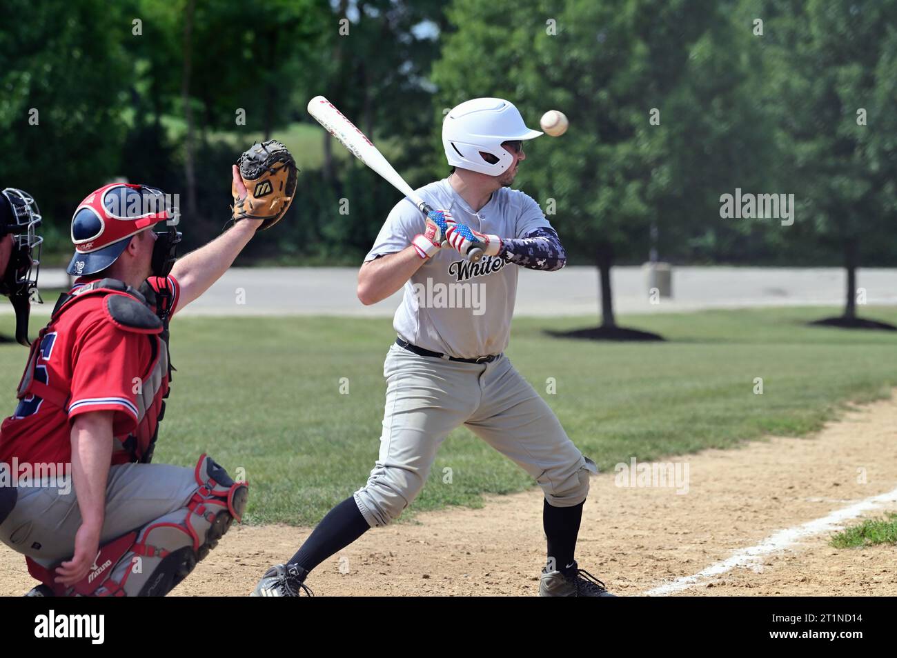 Spring Grove, Illinois, USA. Ein Batter, der einen hohen Spielraum für einen Ball aus der Schlagzone herausnimmt. Stockfoto