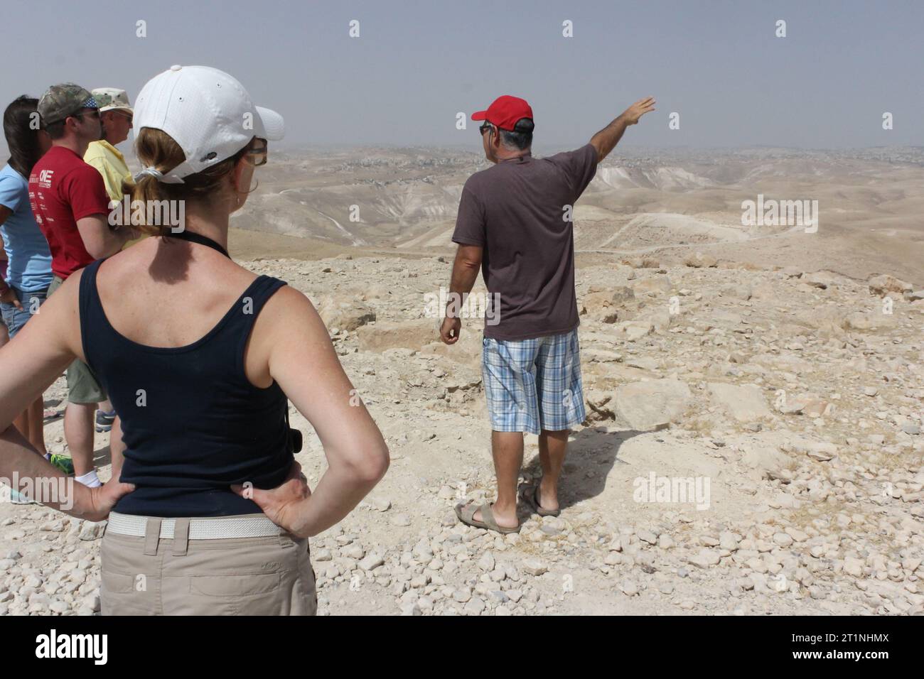 Ein Reiseleiter erklärt Reisenden Details über die Judäische Wüste in Israel. Stockfoto