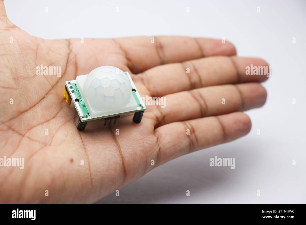 PIR-Sensormodul zur Bewegungserkennung in Roboterprojekten in der Hand. Nützliche elektronische Komponenten für elektronische Projekte Stockfoto