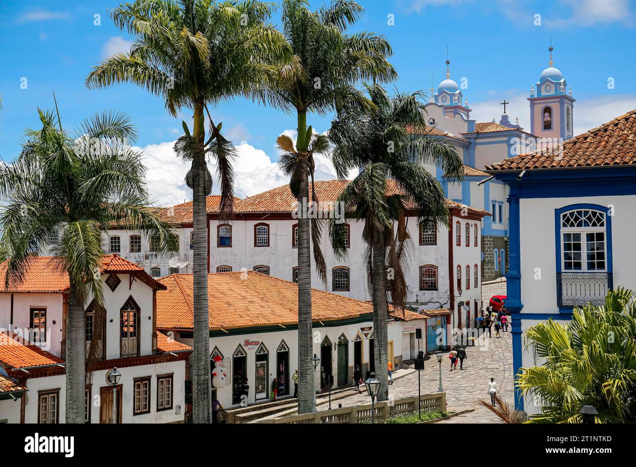 Blick auf traditionelle Häuser und Palmen gesäumte Straße im historischen Zentrum von Diamantina an einem sonnigen Tag, Minas Gerais, Brasilien Stockfoto