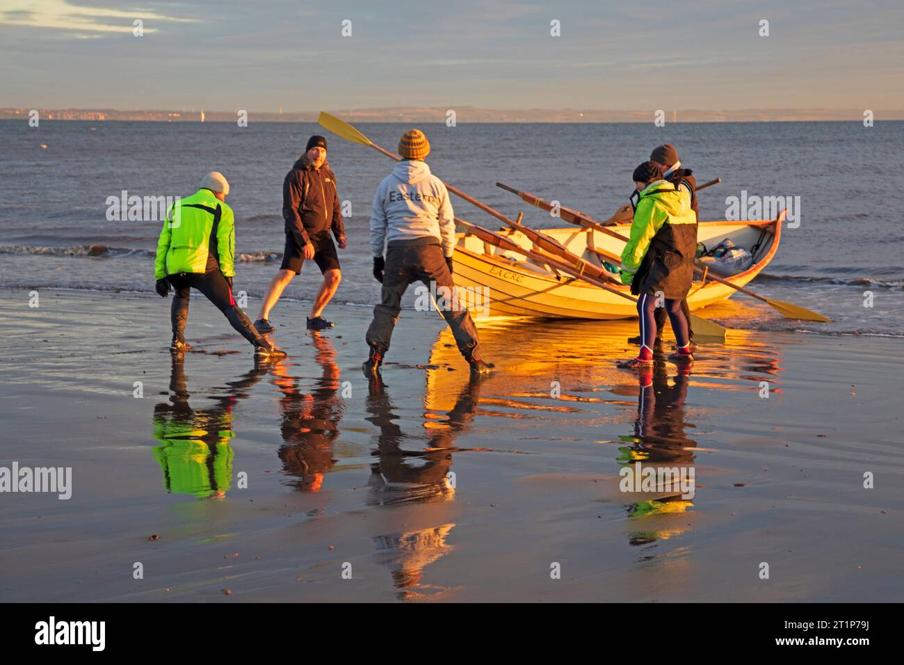 Portobello, Edinburgh, Schottland, Großbritannien. Oktober 2023. Kalter Sonnenaufgang am Meer mit einer Temperatur von 3 Grad Celsius und kühlem Wind mit 16 km/h und möglichen Böen von 34 km/h für diejenigen, die das wunderschöne Morgenlicht genießen. Im Bild: Die Crew des Eastern Amateur Coastal Rowing Club hält sich an, bevor sie sich von der Küste des Firth of Forth aufmacht. Stockfoto