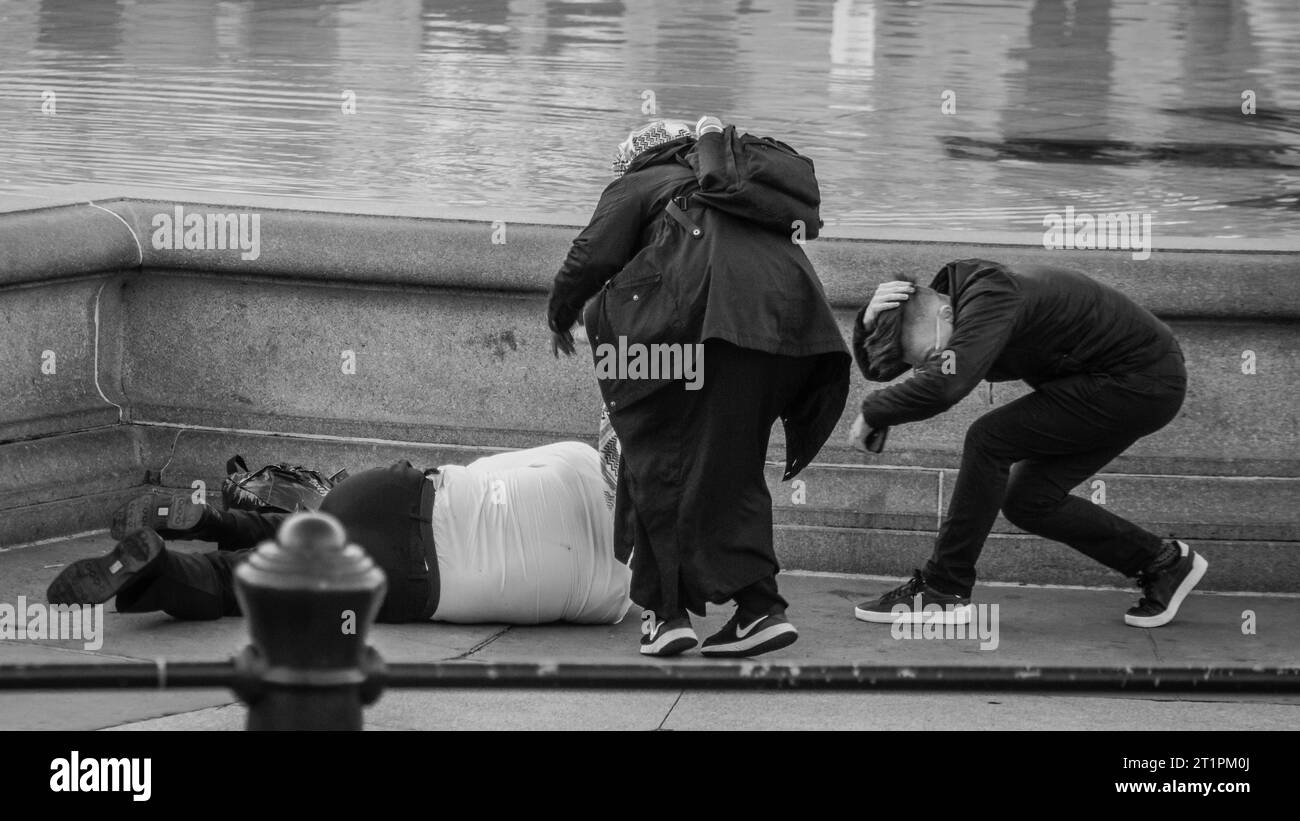 Ein Mann wird von einem Feuerwerk getroffen, und andere ziehen sich zurück, als sie beim Pro-palästinensermarsch in London helfen. Stockfoto
