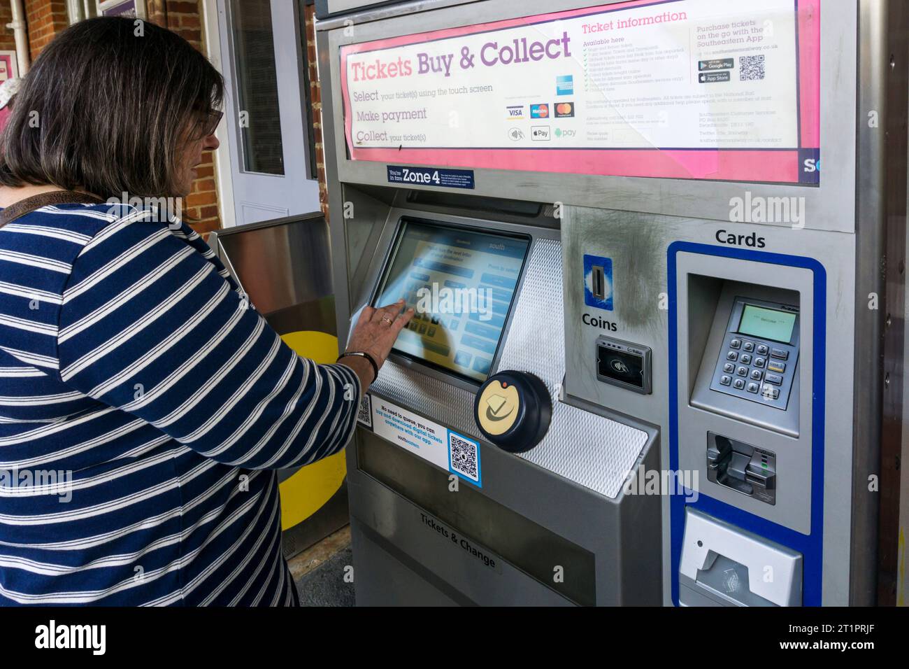 Frau, die Eisenbahnfahrkarten an einem südöstlichen Bahnfahrkartenautomat vor dem Bahnhof Shortlands im Süden Londons kauft. Stockfoto