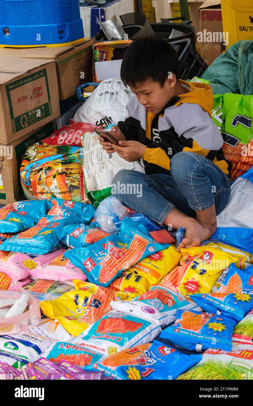 Cau Marktszene, Vietnam. Hmong Boy mit seinem Handy. Provinz Lao Cai. Stockfoto